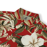 Close-up of white blossoms and green leaves on a vibrant red fabric.