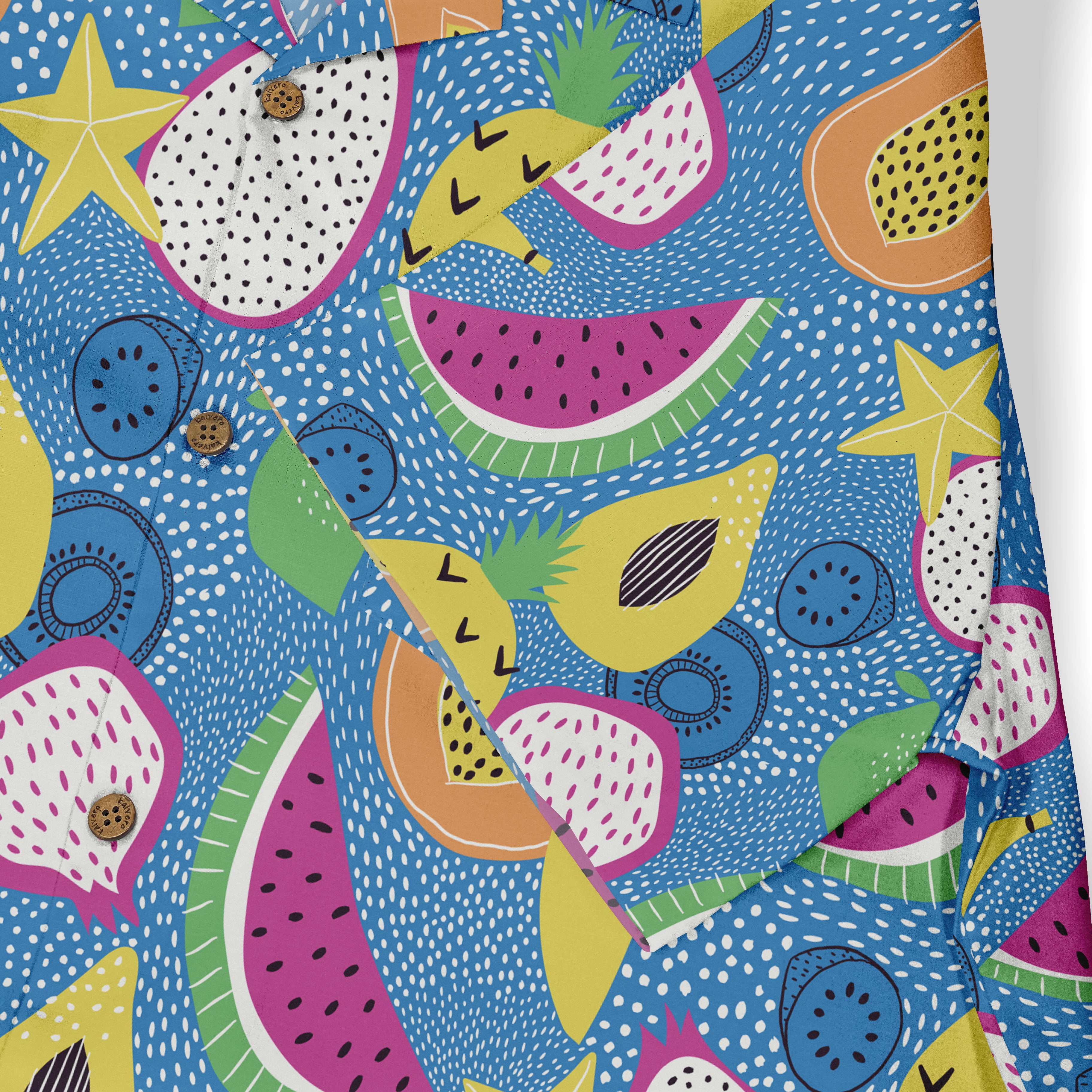 Close-up of a Hawaiian shirt showcasing a playful fruit pattern with various tropical fruits like watermelon, pineapple, and papaya on a blue dotted background, highlighting vibrant and fun summer vibes.