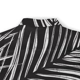 The back collar of a shirt featuring a striking black and white palm leaf pattern, emphasizing the sharp contrast and bold design.