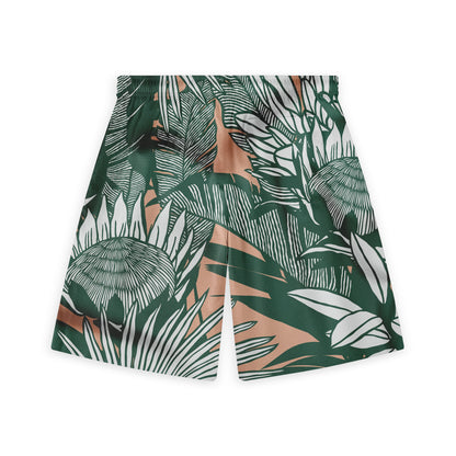 A pair of shorts showcasing a bold tropical pattern with dark green leaves and white detailing on a warm beige background, offering a stylish and adventurous look.