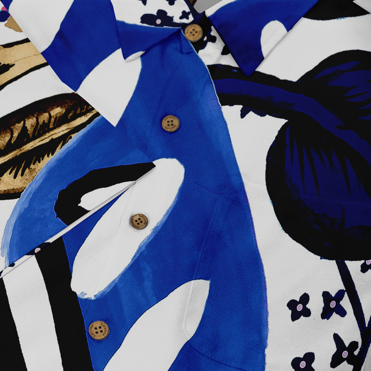 This is a close-up of a shirt featuring a bold, abstract design with vibrant blue and black elements, accented by wooden buttons. The pattern includes large, striking shapes with intricate details, set against a white background, creating a dynamic and visually captivating look.